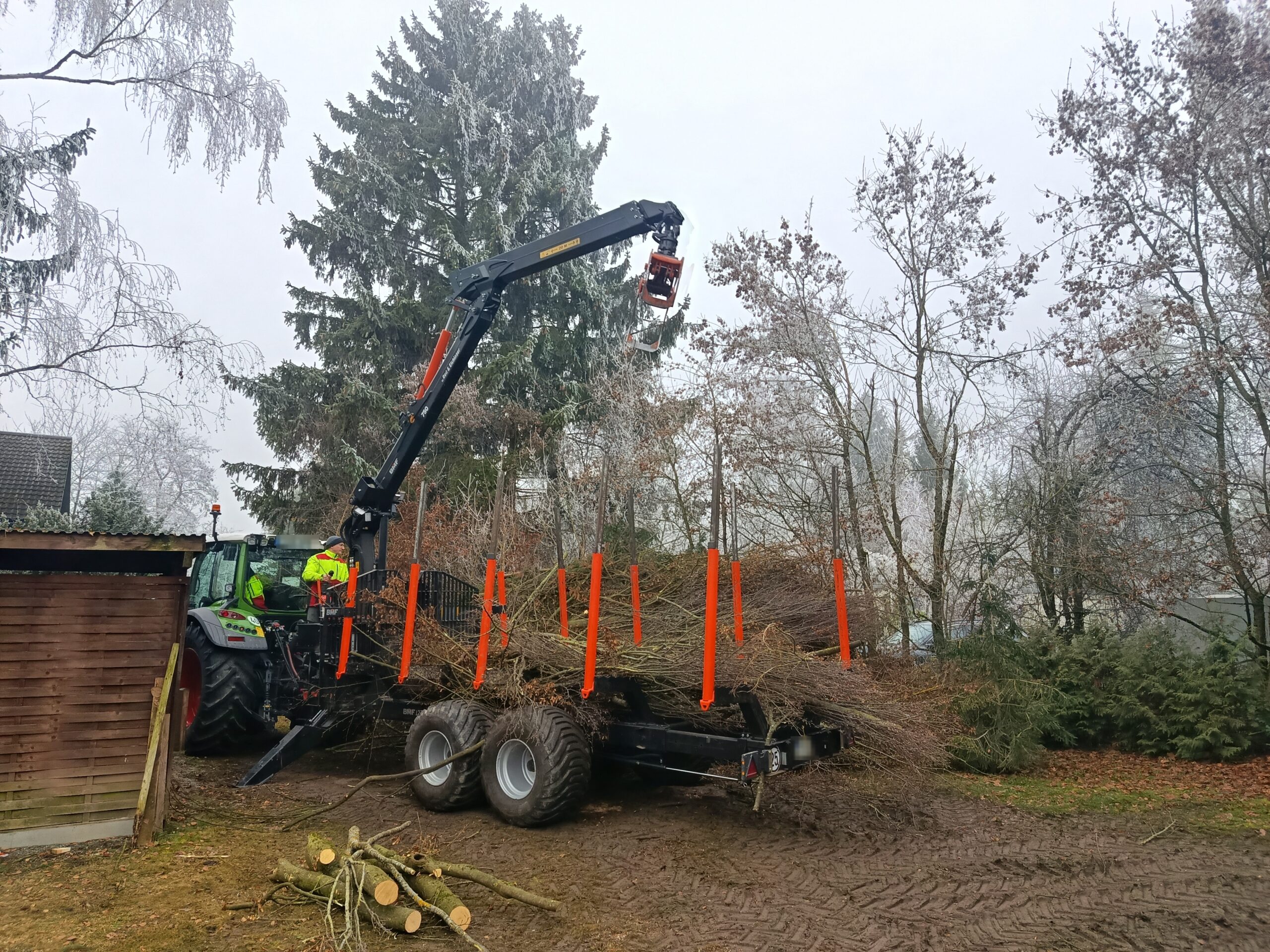 Rückewagen mit Kran bei der Beladung von Astmaterial
